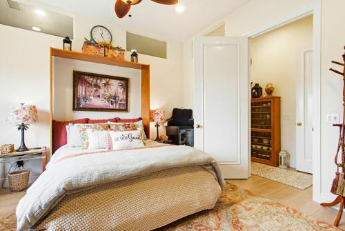 a bedroom with a bed and a clock on the wall at Morning Glory Retreat-Private Lux 1-Bedroom Suite in a Tropical Resort Setting in Vista