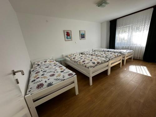 a room with three beds and a window at Apartmani Ivana in Prozor