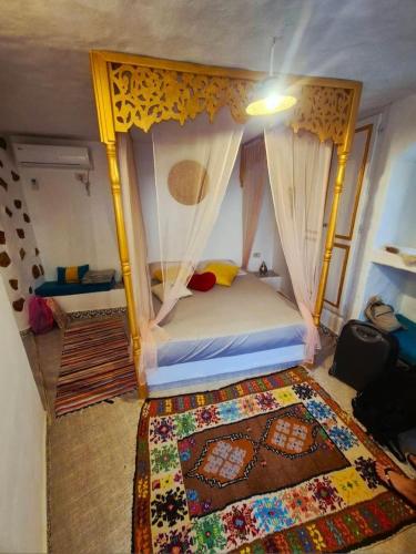 a bedroom with a bed with a canopy at Chambre d'hôtes medenine in Medenine