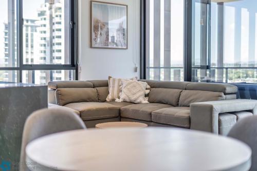 a living room with a couch and tables and windows at Ocean View 3 Bedroom with Great Facilities - Hosted by Gold Coast Luxury Resorts in Gold Coast