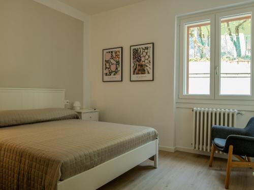 a bedroom with a bed and a window and a chair at Casa Rita - Casa vacanze - free parking terrazze e giardino area barbecue TOP CLASS in Predore