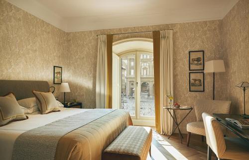 a bedroom with a large bed and a window at Rocco Forte Hotel Savoy in Florence