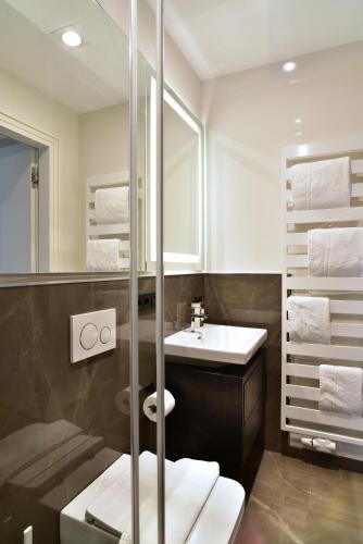 a bathroom with a sink and a toilet and a mirror at SAXX Apartments Hagen in Hagen