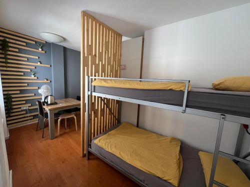 a room with two bunk beds and a desk at Cukrarna Guest Accommodation in Kranj
