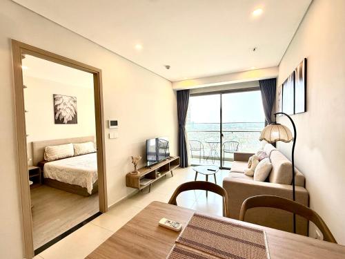 a living room with a couch and a bed and a window at The Song Vung Tau Apartment - Căn Hộ Du Lịch Biển Vũng Tàu in Xã Thang Tam
