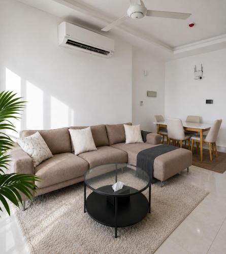 a living room with a couch and a table at Cozy Apartment in Boshar in Muscat