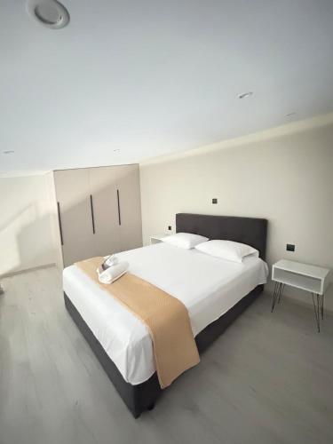 a bedroom with a large white bed and a table at Villa Ziglos by Karda Suites in Chios