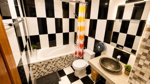 a bathroom with a black and white checkered wall at LOTUS SERENITY Hostel in Siem Reap