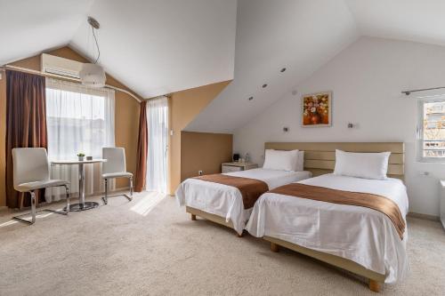 a large bedroom with two beds and a table at Sienna Residence in Skopje