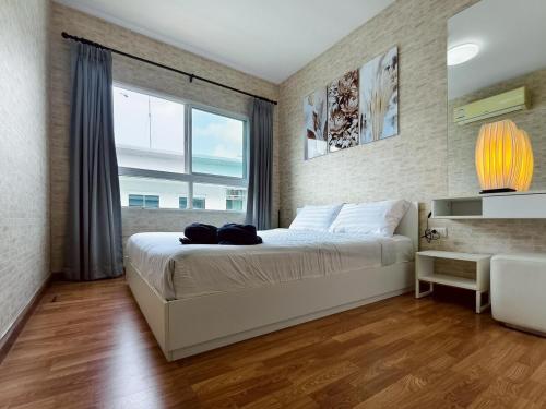 a bedroom with a large bed and a large window at Condo in Hua Hin in Hua Hin
