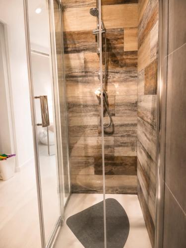 a shower with wooden walls and a glass door at Casa Gimaga in Pozzuoli