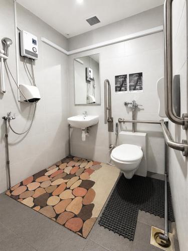 a bathroom with a toilet and a sink at Sandpiper Hotel Singapore in Singapore