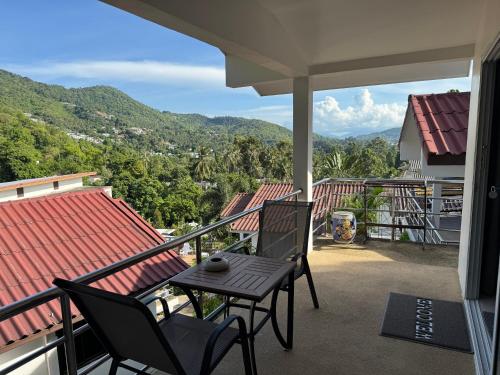 eine Terrasse mit zwei Stühlen und einem Tisch auf einem Balkon in der Unterkunft BRW Samui in Bophut 