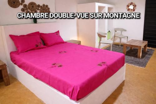 a bedroom with a pink bed in a room at Casa Lantana in Antsiranana