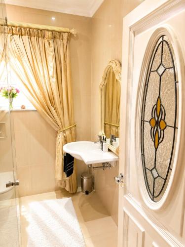 a bathroom with a sink and a shower and a mirror at Luxury Beach Apartments in Amanzimtoti