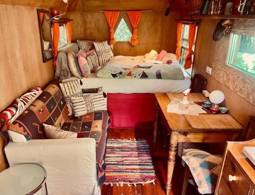 a small room with two beds and a table at Kuscheliger Zirkuswagen im Wildgarten in Witzenhausen