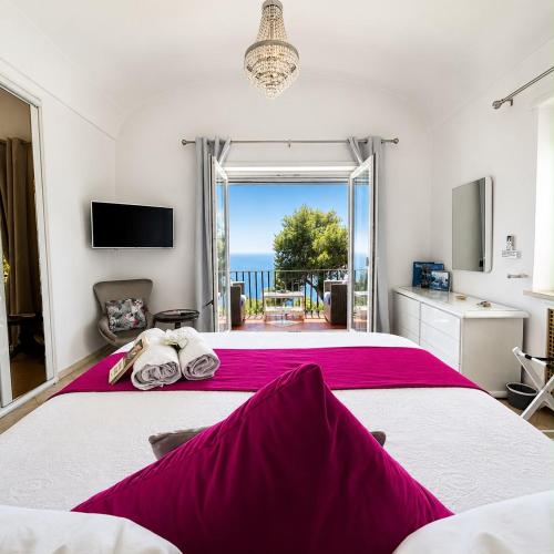 a bedroom with a large bed with a view of the ocean at MARVELOUS CAPRI - Sea View Villa in Capri