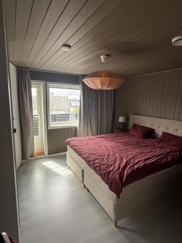 a bedroom with a bed and a large window at Lykkebo in Stavanger