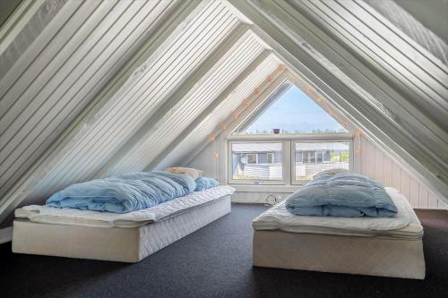 two beds in a room with a window at 299-Ringkobing-Havklitvej-24 in Klegod