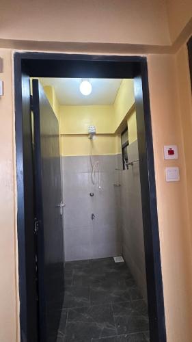a bathroom with a shower with a glass door at Lucci suites in Kisumu