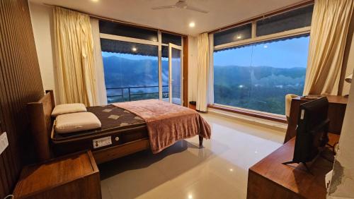 a bedroom with a bed and a large window at Celestial Nymph by Natureloom in Vagamon