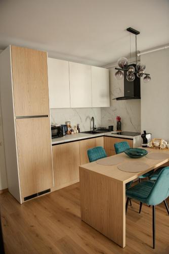a kitchen with a wooden table and a dining room at RIVER VIEW & Private Parking - Baia Mare in Baia Mare