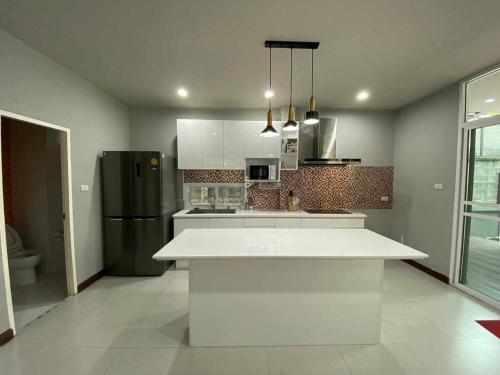 a kitchen with a white counter and a refrigerator at Home Sukhumvit 49 Soi 14 in Bangkok