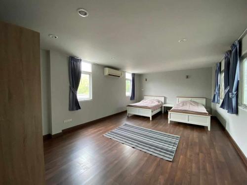 a living room with two beds and a rug at Home Sukhumvit 49 Soi 14 in Bangkok