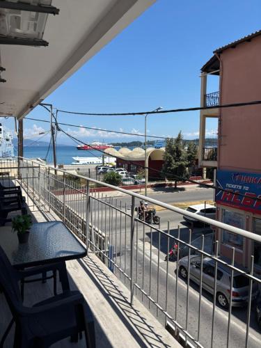 a balcony with a table and a view of a street at Ionian Port Suite in Ágios Rókkos