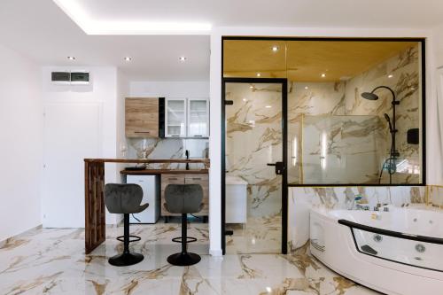 a bathroom with marble walls and a tub and two chairs at Gallus Inn in Aleksinac