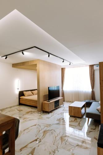 a living room with a bed and a television on a marble floor at Gallus Inn in Aleksinac