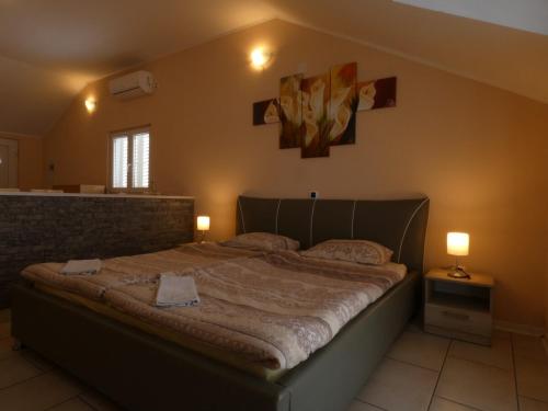 a large bed in a bedroom with two lamps at Nature sunset apartment in Ubli