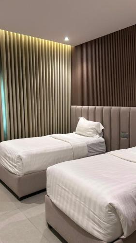 two beds in a hotel room withskirts at فيلا درة العروس 2 in Durat Alarous