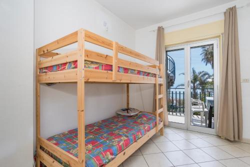 a bunk bed in a room with a balcony at I Ciottoli Dello Ionio in Mascali