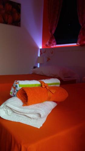 two towels sitting on top of a bed with a light at Villetta Dote in Casarano