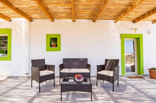 a patio with chairs and a table and a wooden ceiling at Sunrise apartments in Menetaí
