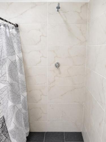 a bathroom with a shower with white tiles at Finca fercho rozo in Rozo