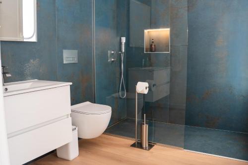 a bathroom with a toilet and a glass shower at Pérola de São João in Calheta