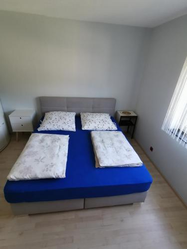 a bedroom with a blue bed in a white room at Zimmer zum übernachten wg in Münsingen