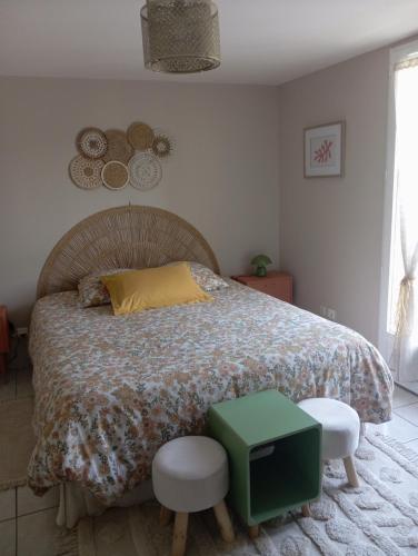 a bedroom with a bed and two stools at Les Cyprès in Vienne
