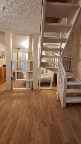 a room with a staircase and a living room with wooden floors at Cottages Delloress in Jūrmala
