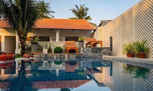a swimming pool in front of a house at Như House Apartment - Phú Quốc in Phú Quốc