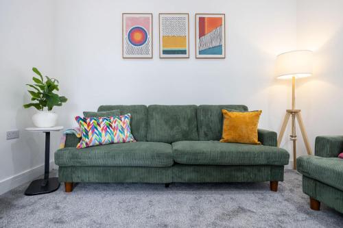 a green couch with pillows in a living room at The Loft Apartment in Elland
