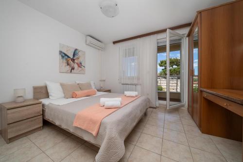 a bedroom with a large bed and a balcony at Apartmani Putnik in Baška Voda