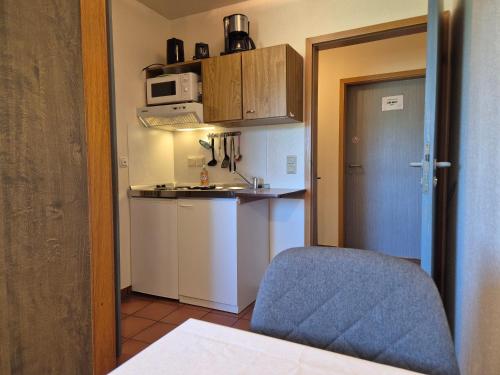 a small kitchen with a sink and a microwave at Ferienwohnung zum Zander - Sonniger Weitblick übers Feld in Wester-Ohrstedt