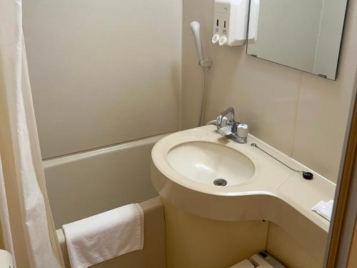 a small bathroom with a sink and a mirror at Hotel Yamadaso in Nago