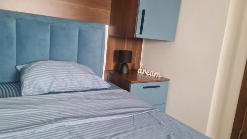a bedroom with a bed and a night stand with a lamp at Vivo in Jagodina