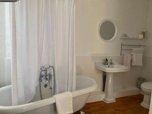a white bathroom with a tub and a sink at Les Papillons in Verteillac