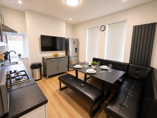 a kitchen and living room with a table and chairs at SidemerseyLivings - Step-Free 4BR Home, Ground Floor Bed & Bath, Private Gated Parking in Liverpool