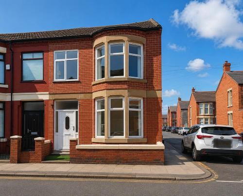 a red brick house with white windows on a street at SidemerseyLivings - Step-Free 4BR Home, Ground Floor Bed & Bath, Private Gated Parking in Liverpool